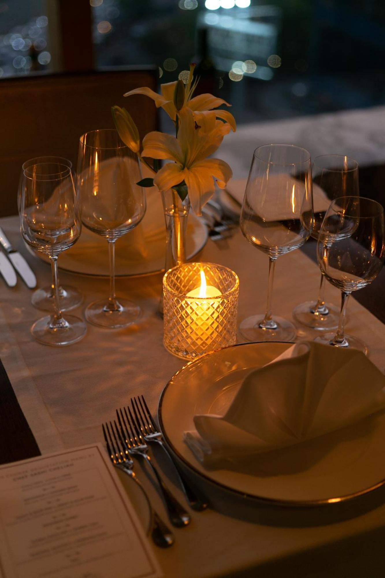 The Leela Ambience Gurugram Hotel & Residences - The Luxury Urban Sanctuary Gurgaon Zewnętrze zdjęcie A candle on a dinner table